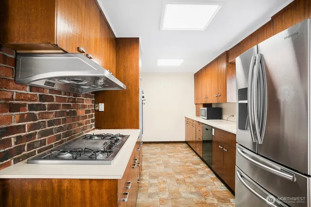 a kitchen with stainless steel appliances granite countertop a stove a sink and a refrigerator