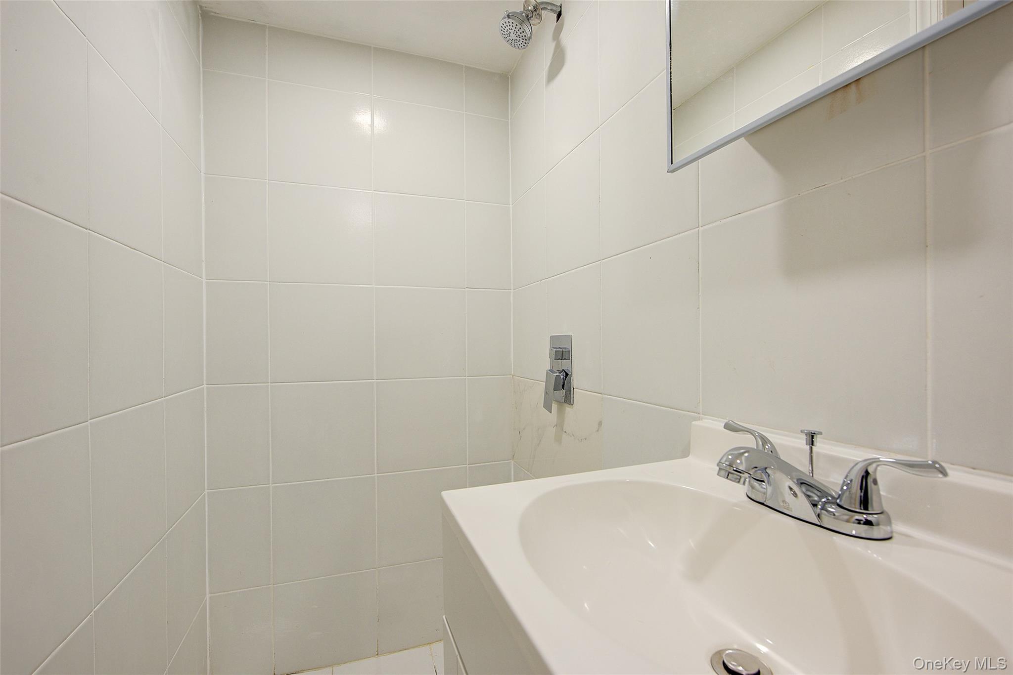 164-38 76th Road Queens, NY 11366 - Photo 32 of 44 a bathroom with a sink and a mirror