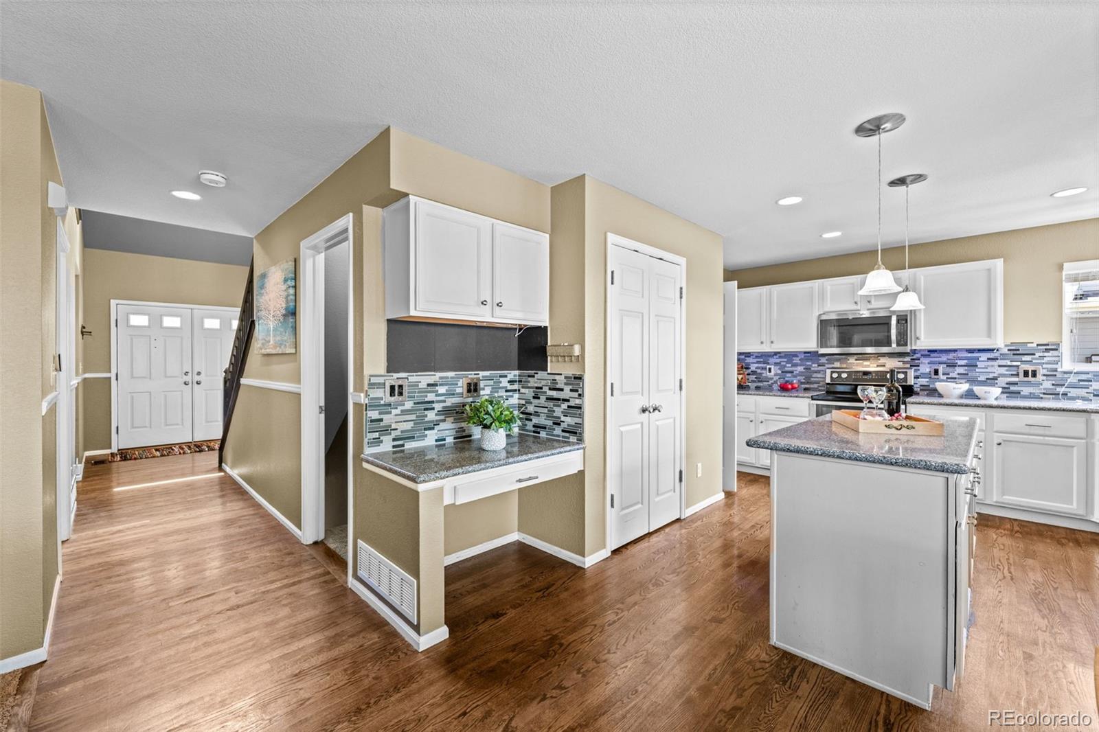 1735 Spring Water Lane Highlands Ranch, CO 80129 - Photo 18 of 50 a kitchen with white cabinets and stainless steel appliances