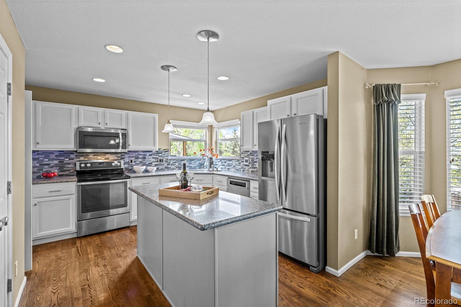 1735 Spring Water Lane Highlands Ranch, CO 80129 - Photo 9 of 50 a kitchen with stainless steel appliances granite countertop a refrigerator a stove a sink and a microwave