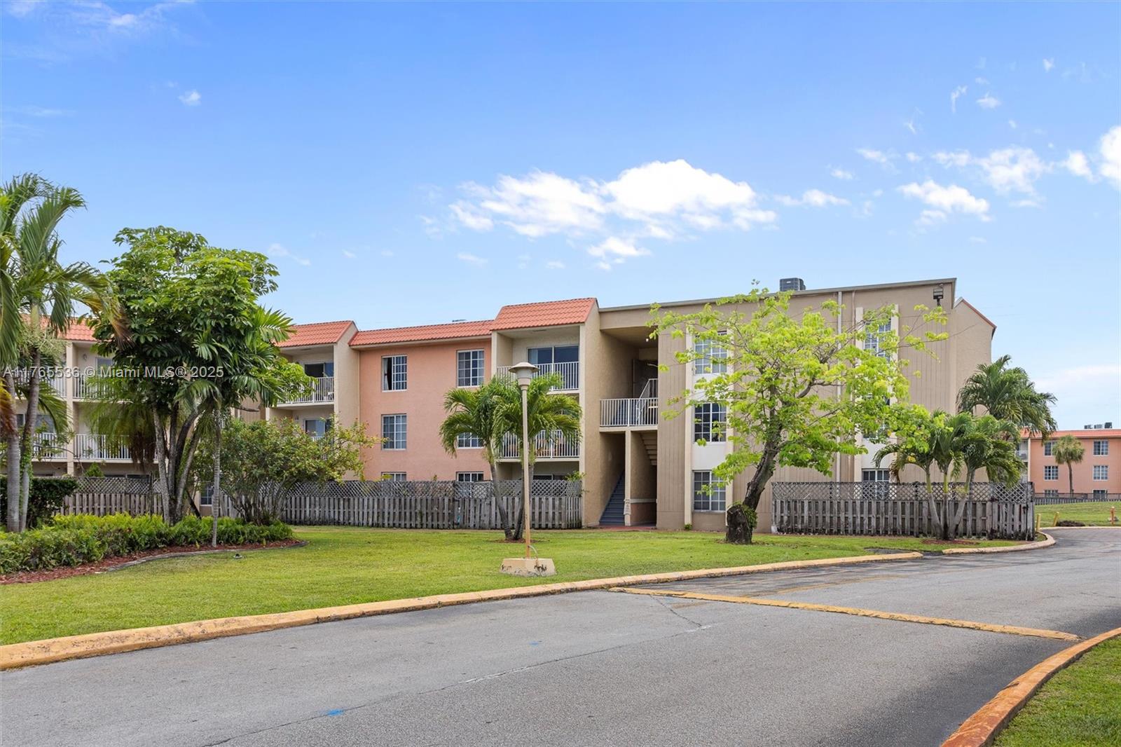 4920 Northwest 79th Avenue, Unit 309 Doral, FL 33166 - Photo 2 of 33 a view of a house with a big yard and large trees