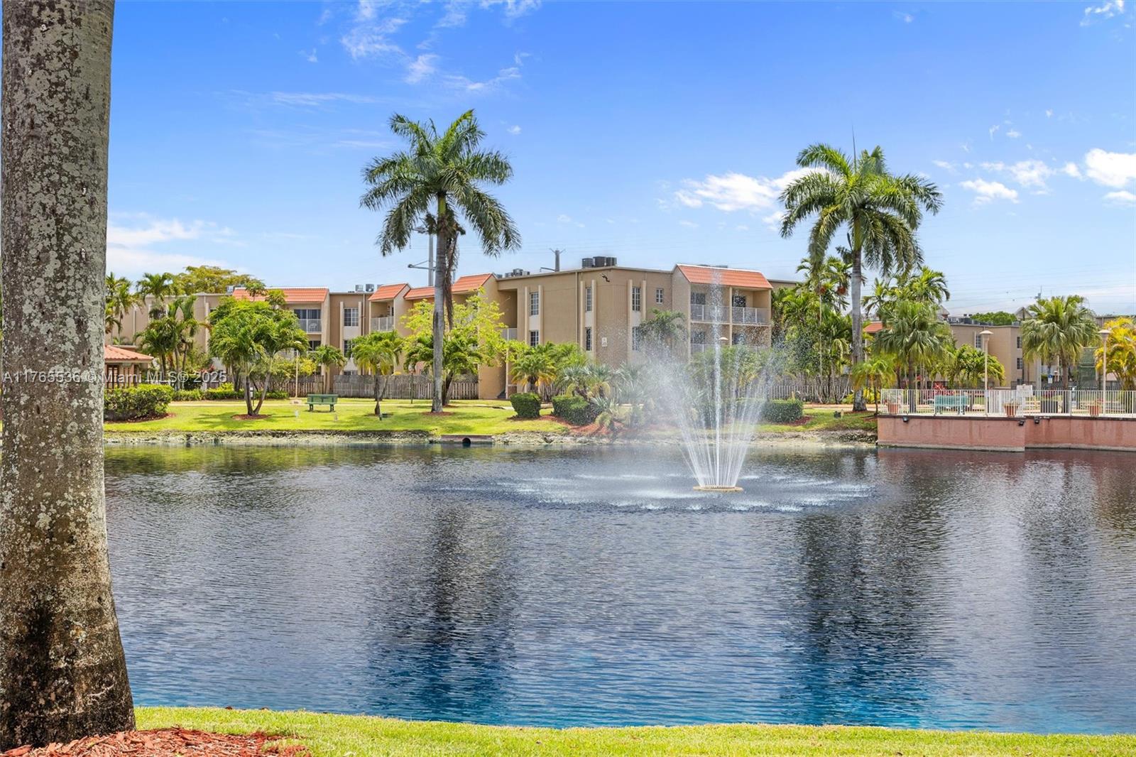 4920 Northwest 79th Avenue, Unit 309 Doral, FL 33166 - Photo 22 of 33 a view of a lake with a palm tree