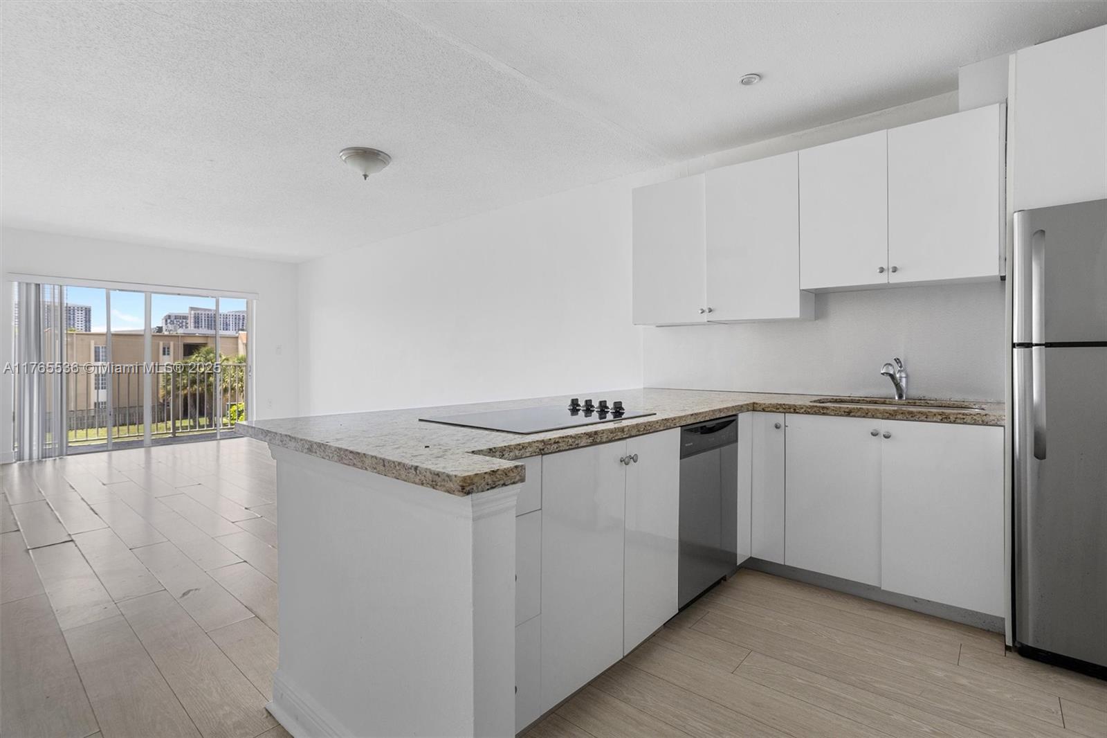 4920 Northwest 79th Avenue, Unit 309 Doral, FL 33166 - Photo 8 of 33 a kitchen with granite countertop white cabinets and white appliances