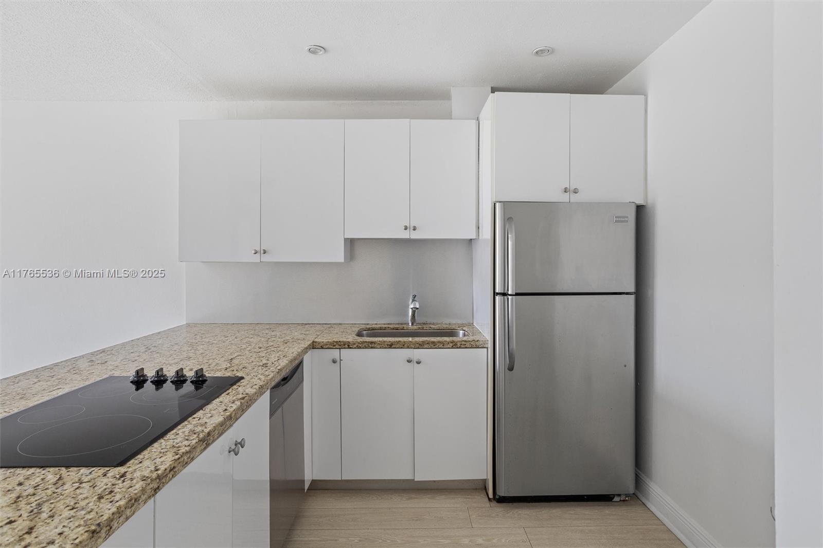 4920 Northwest 79th Avenue, Unit 309 Doral, FL 33166 - Photo 9 of 33 a kitchen with a stove refrigerator and cabinets