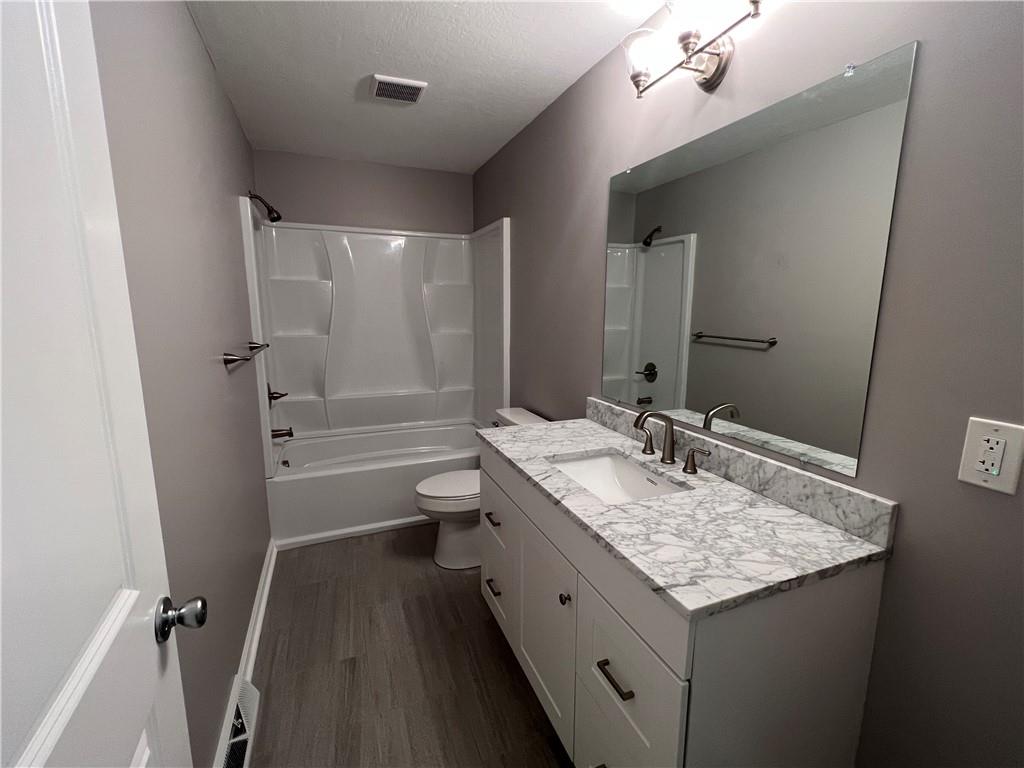 945 McElree Road Washington, PA 15301 - Photo 12 of 16 a bathroom with a granite countertop sink a toilet a mirror and shower