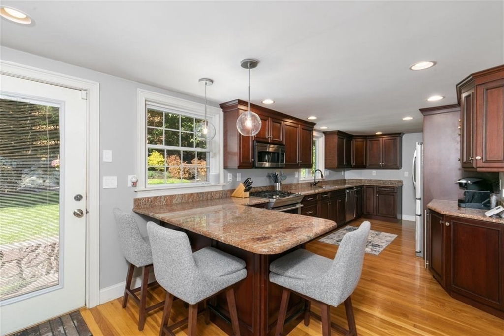 31 Robert Street Wakefield, MA 01880 - Photo 17 of 41 a kitchen with stainless steel appliances granite countertop a kitchen island a stove a table and chairs