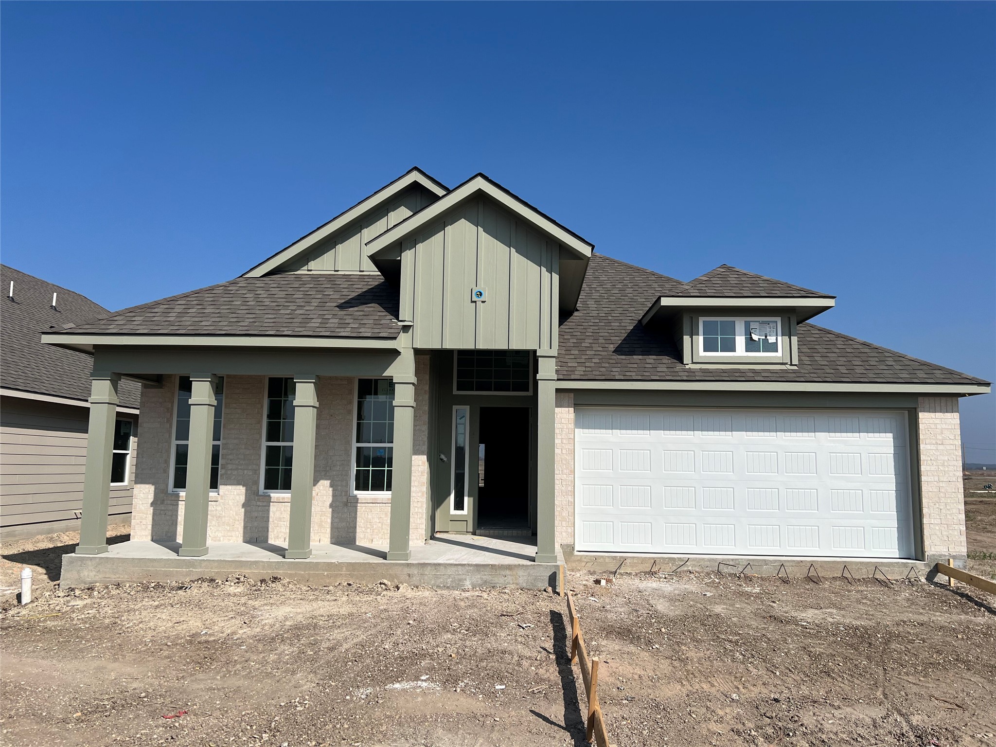 216 Gus Loop Georgetown, TX 78626 - Photo 1 of 1 View of front of house with roof with shingles, driveway, board and batten siding, and brick siding