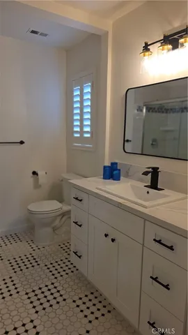a bathroom with a sink toilet and mirror