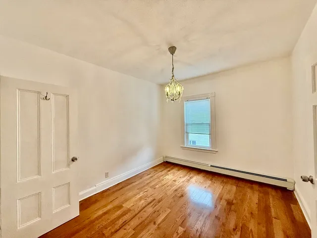 a view of a room with window wooden floor and chandelier