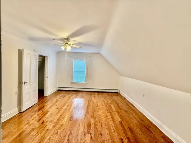 a view of a room with wooden floor and a ceiling fan
