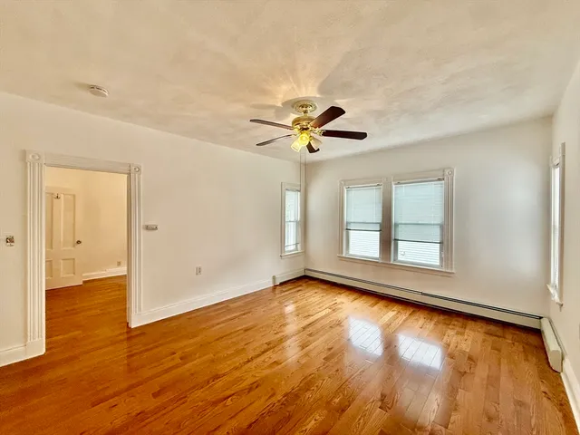 a spacious bedroom with a bed and wooden floor