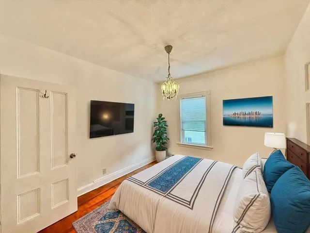a view of empty room with wooden floor and window
