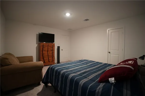 a bedroom with a bed and a television