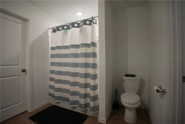 a bathroom with a toilet and a shower