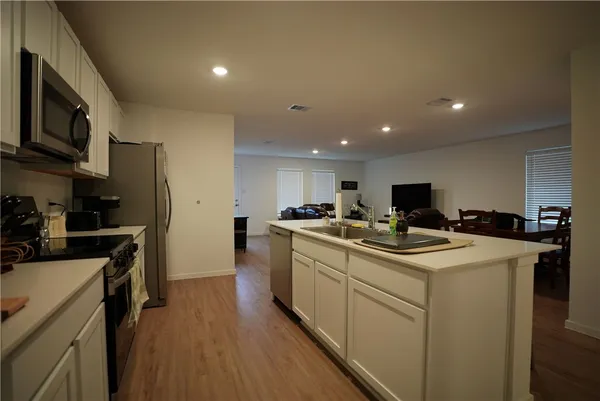 a view of kitchen with sink microwave and refrigerator