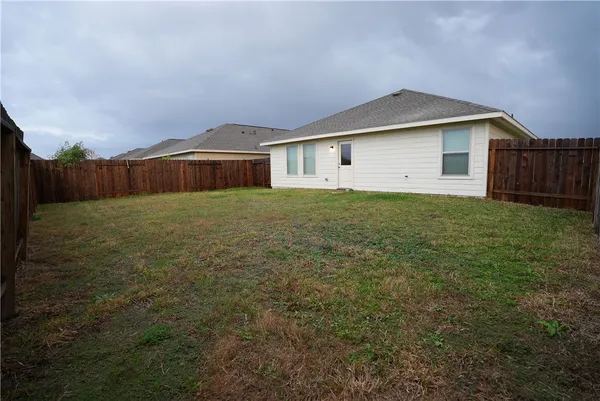 a front view of house with yard and trees in the background