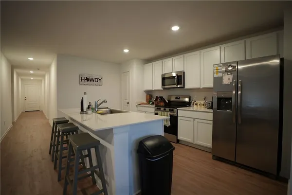 a kitchen with a sink a refrigerator a stove a microwave and cabinets