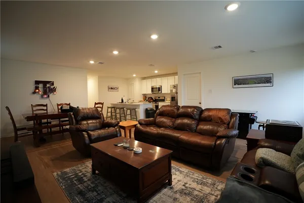 a living room with furniture a rug and a dining table