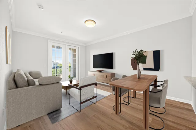 a view of an empty room with wooden floor and window
