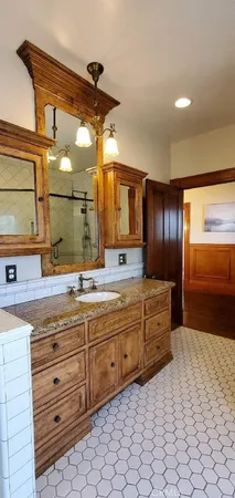 a bathroom with a granite countertop sink and a mirror