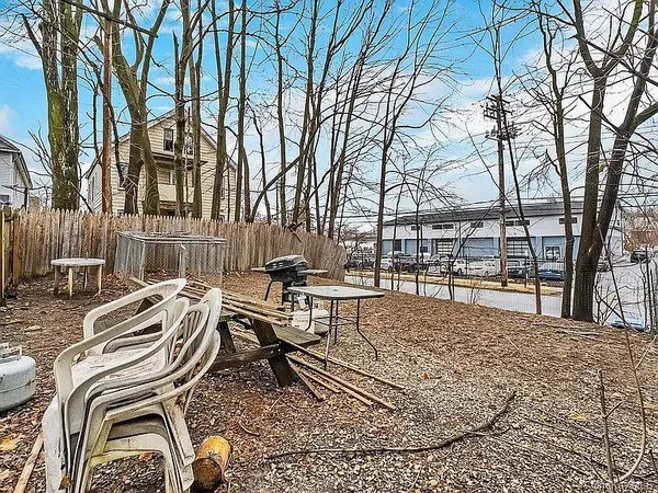 a view of a patio with chairs and a table and chairs with wooden fence
