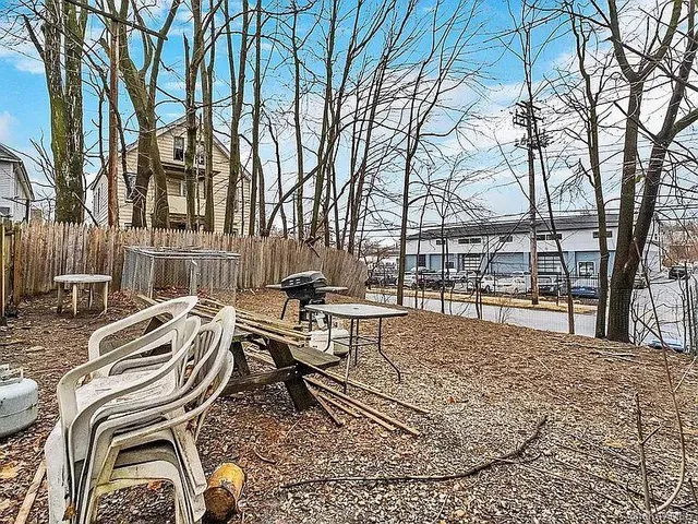 a view of a patio with chairs and a table and chairs with wooden fence