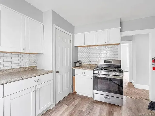 a kitchen with a stove and white cabinets