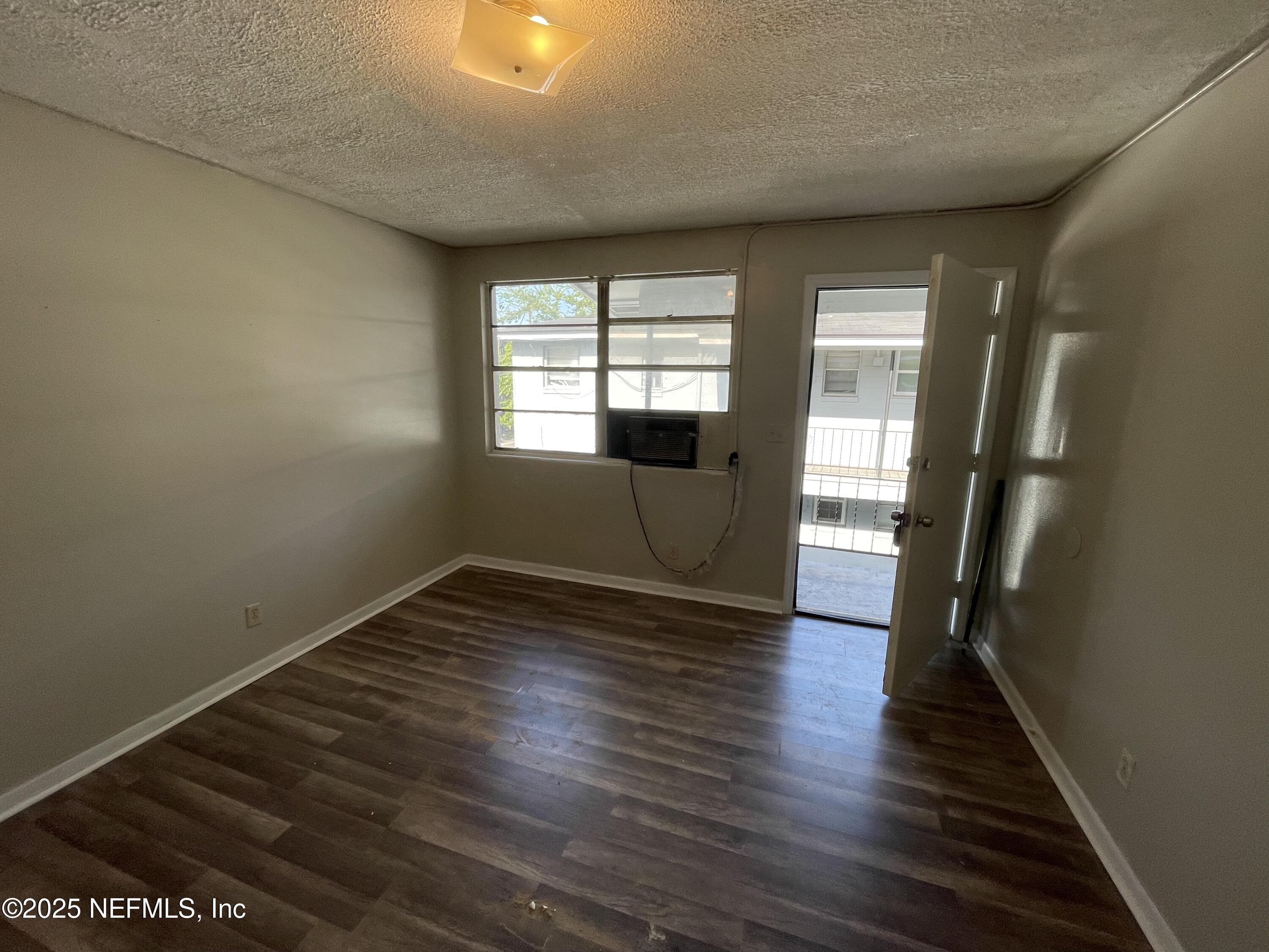1624 West 36th Street, Unit 3 Jacksonville, FL 32209 - Photo 3 of 7 wooden floor in an empty room with a window