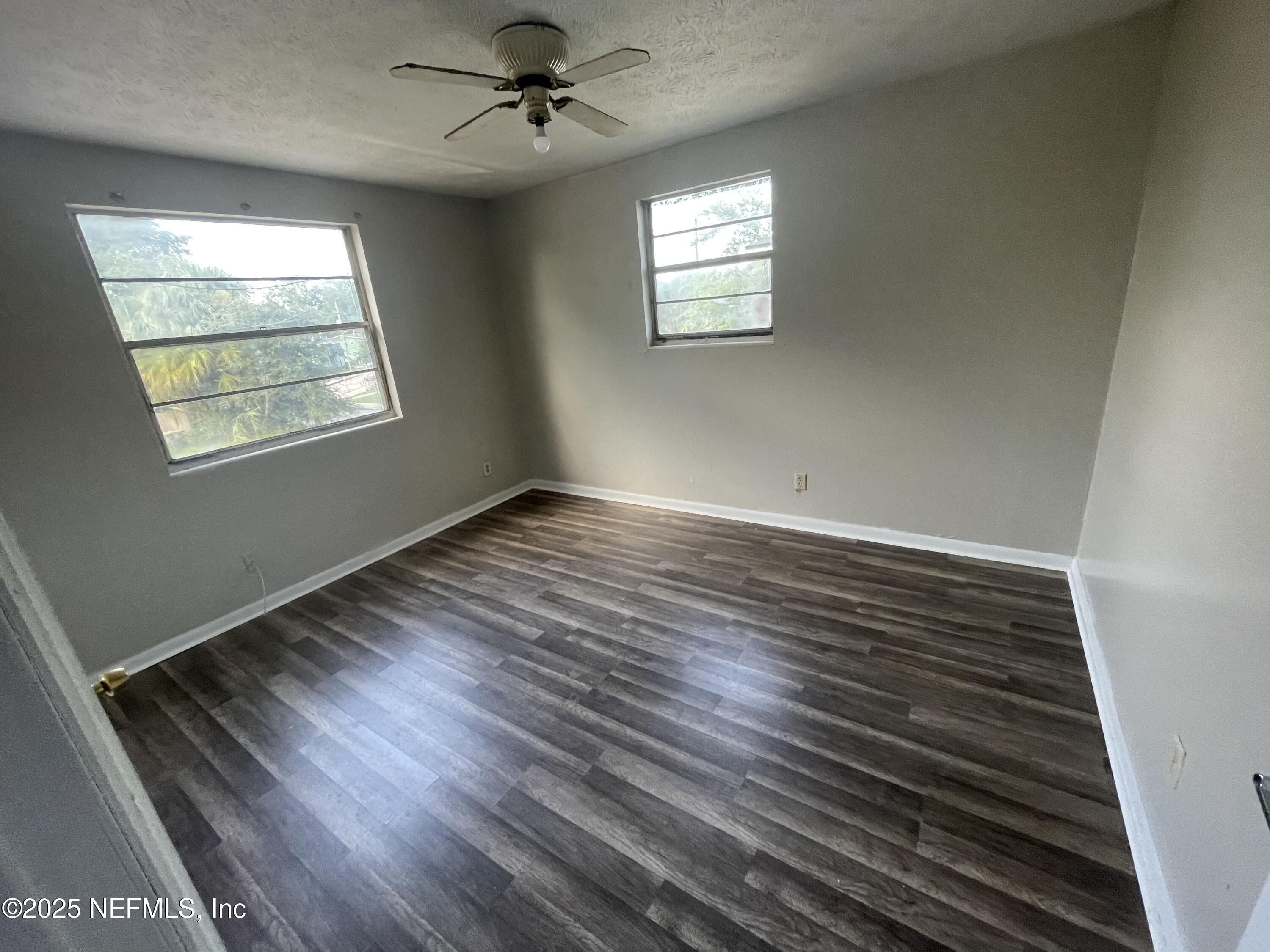 1624 West 36th Street, Unit 3 Jacksonville, FL 32209 - Photo 5 of 7 a view of an empty room with wooden floor and a window