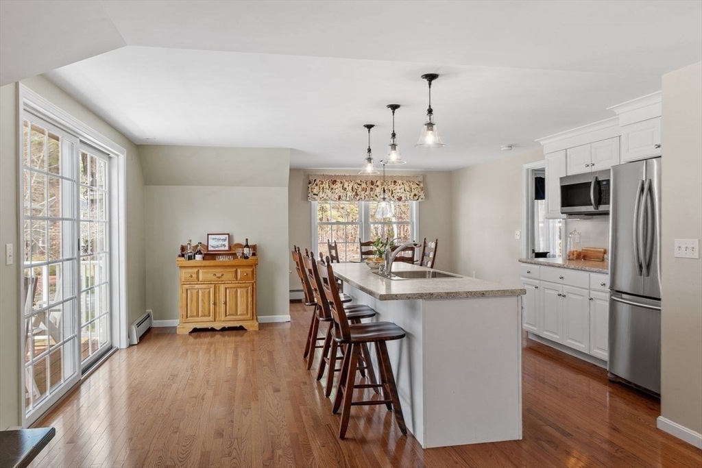 17 Enfield Drive Andover, MA 01810 - Photo 22 of 37 a kitchen with stainless steel appliances a dining table chairs refrigerator and sink