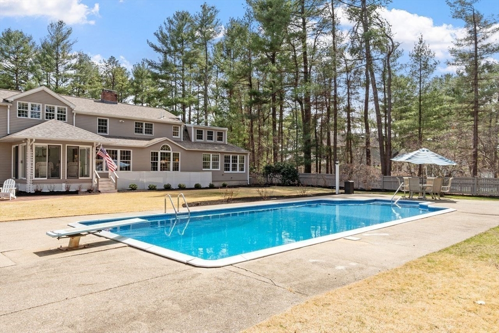 17 Enfield Drive Andover, MA 01810 - Photo 32 of 37 a view of a swimming pool with lawn chairs under an umbrella