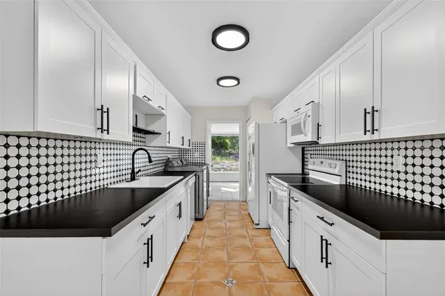 a kitchen with granite countertop a sink and a stove top oven