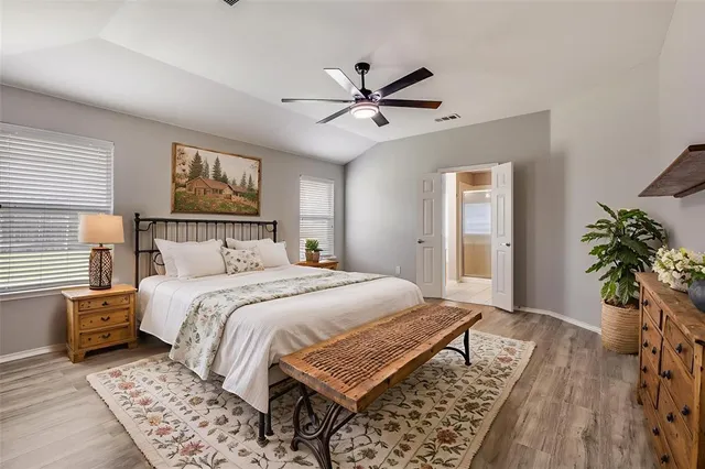 a bedroom with a large bed and a chandelier