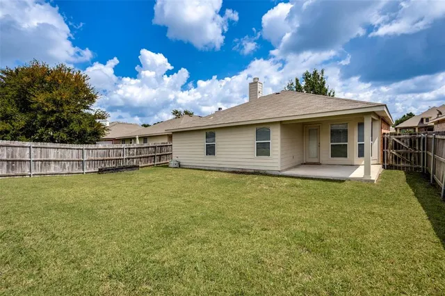 a backyard of a house with table and chairs