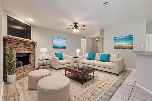 a living room with furniture a fireplace and a flat screen tv