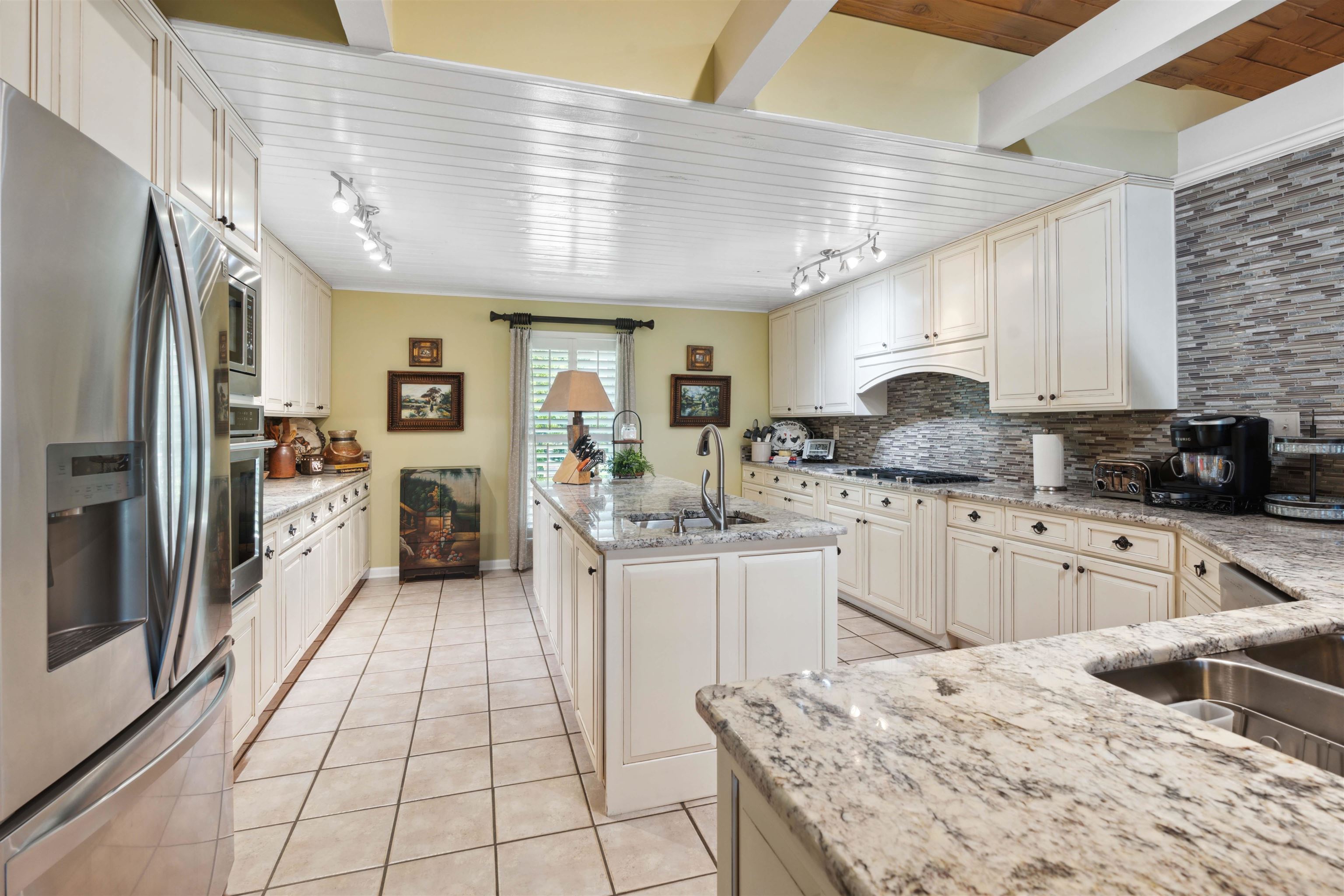 155 Carlins Road Hornsby, TN 38044 - Photo 13 of 40 Kitchen featuring tasteful backsplash, rail lighting, an island with sink, appliances with stainless steel finishes, and sink