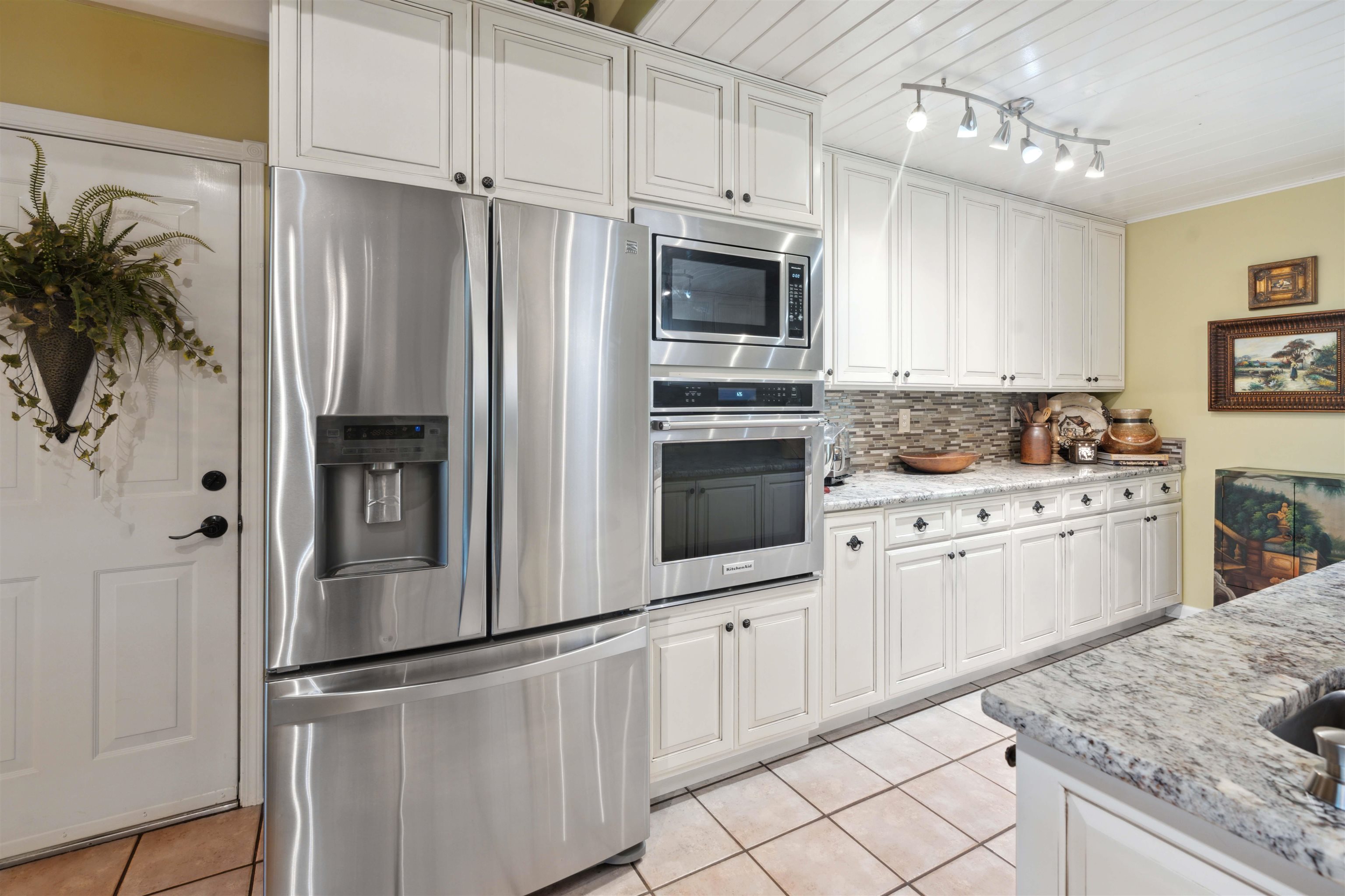 155 Carlins Road Hornsby, TN 38044 - Photo 15 of 40 Kitchen featuring tasteful backsplash, stainless steel appliances, light tile patterned floors, and white cabinets