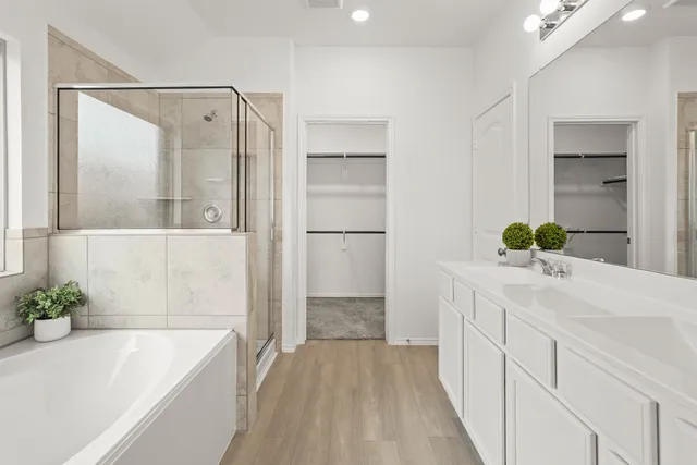 a bathroom with a tub sink and mirror