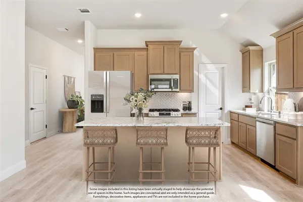 a kitchen with kitchen island granite countertop a sink and cabinets