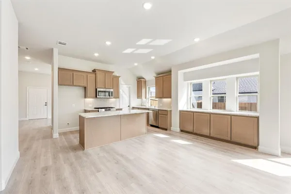 a large kitchen with kitchen island a sink stainless steel appliances and cabinets