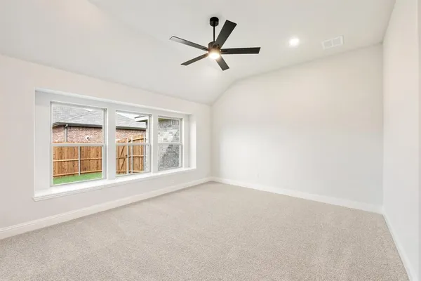 an empty room with ceiling fan and windows