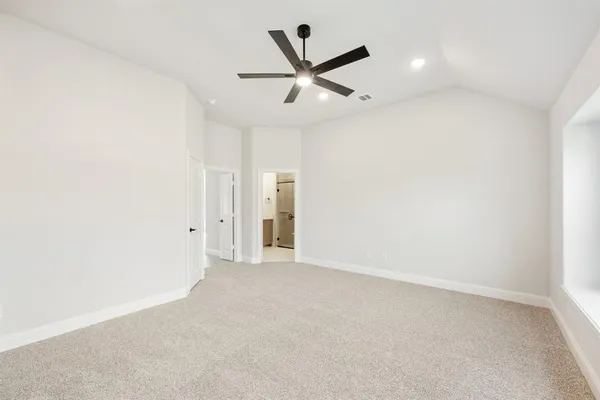 an empty room with ceiling fan and windows