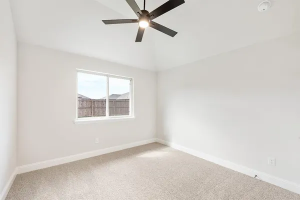 an empty room with a window and a fan