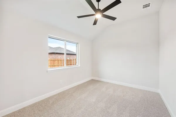 an empty room with a window and a fan
