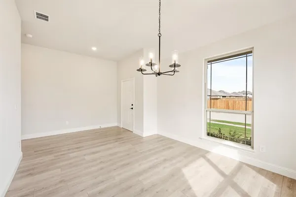 a view of empty room with wooden floor and window