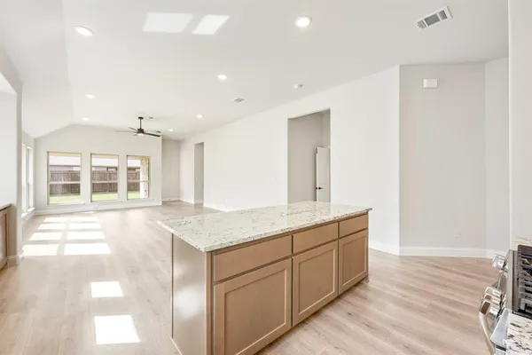 a hall with kitchen island white cabinets and sink