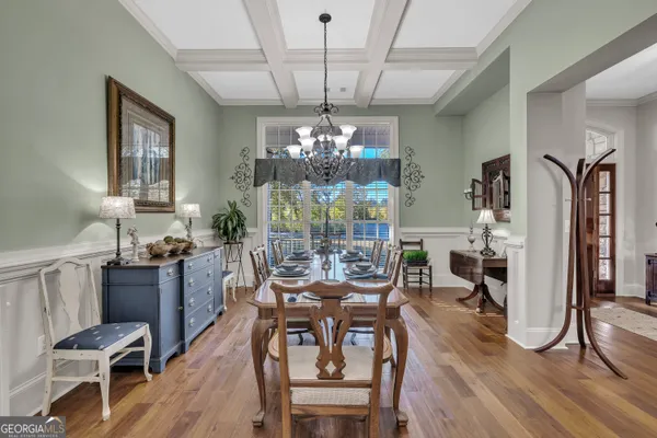 a view of a dining room with furniture a chandelier and wooden floor