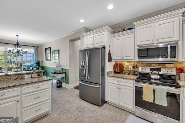 a kitchen with stainless steel appliances granite countertop a refrigerator and a stove