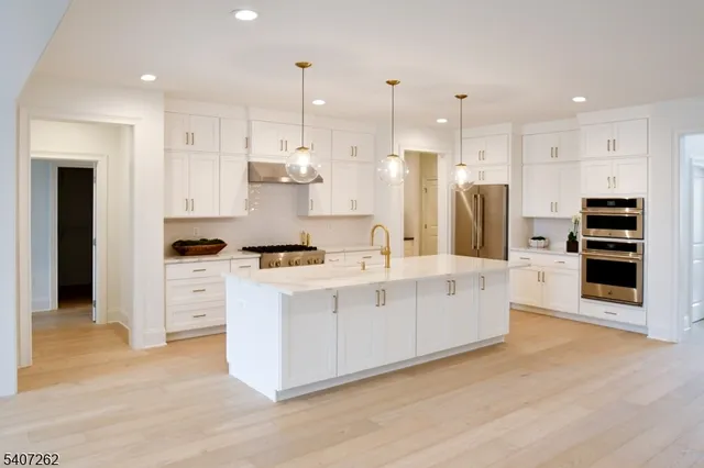 a large white kitchen with stainless steel appliances