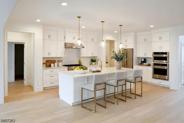 a kitchen with stainless steel appliances kitchen island granite countertop a dining table chairs sink and cabinets